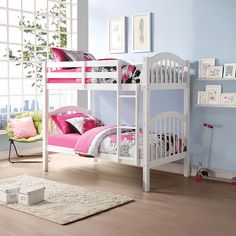 a white bunk bed sitting on top of a hard wood floor next to a window