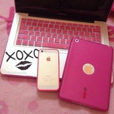 an open laptop computer sitting on top of a pink blanket next to two cell phones