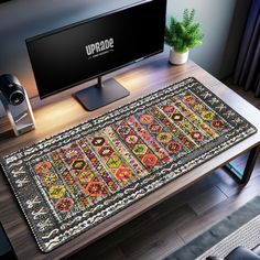 a computer desk with a rug on top of it and a tv in the background