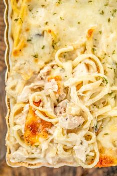 a casserole dish with chicken and noodles in it on a wooden table top