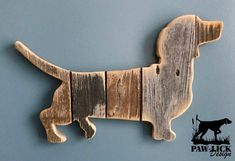 a wooden dachshund dog is hanging on the wall