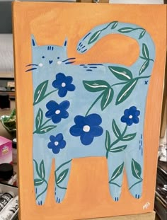 a painting of a cat with blue flowers on it