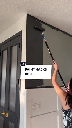 a woman is painting the wall with paint hacks