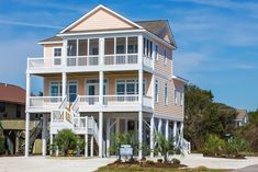 a large white house sitting on top of a sandy beach