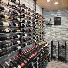 a wine rack filled with lots of bottles of wine next to a wall mounted tv