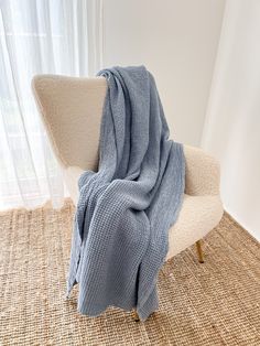 a blue blanket sitting on top of a white chair