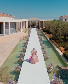 an artist's rendering of a woman in a pink dress walking down a long path