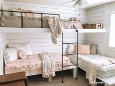 a bedroom with bunk beds and pink blankets on top of the bed, next to a window