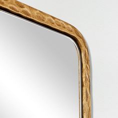 a mirror that is on the wall with a wooden frame and wood grained edges