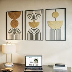 a laptop computer sitting on top of a wooden desk next to a lamp and pictures