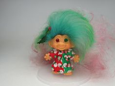 a troll doll with green hair and red dress