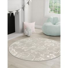 a white rug with elephants on it in a room next to a chair and window