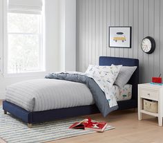 a bedroom with a blue bed and white walls