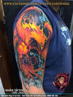 a man with a tattoo on his arm has a dragon and fire design on it