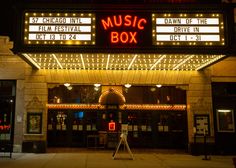 the entrance to a theater with lights on it's marquee and sign reading music box