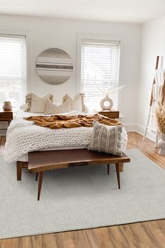 a bedroom with white walls and wooden furniture in the corner, including a large bed