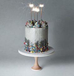 a birthday cake with sprinkles and sparklers on the top is shown