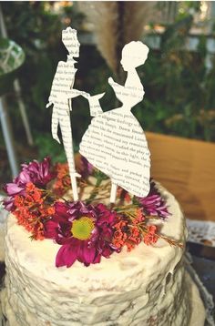 a cake that is sitting on top of a table with paper cutouts in the shape of children's silhouettes