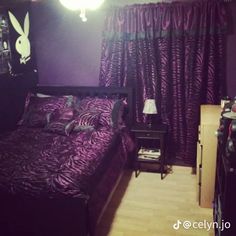 a bed room with a neatly made bed and purple curtains