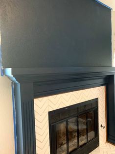 the fireplace is painted black and has white chevrons on it's mantle