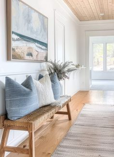 a wooden bench sitting in the middle of a living room next to a door and window