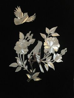 two metal birds and flowers on a black background