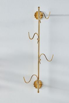 a gold coat rack with two hooks on it