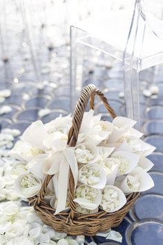 a basket filled with white flowers sitting on top of a blue table cloth covered floor