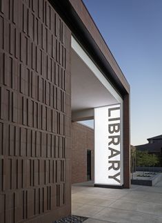 an entrance to a library with the word library on it's side and brick wall