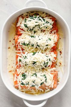 salmon with parmesan cheese and spinach in a white casserole dish