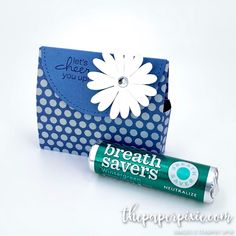 a tube of toothpaste sitting next to a blue box with a white flower on it