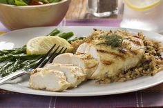 a white plate topped with chicken, rice and asparagus