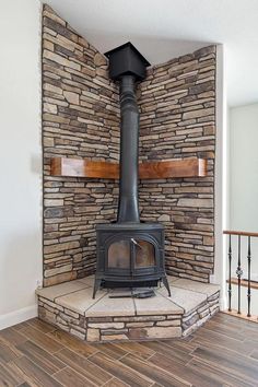 a wood burning stove sitting inside of a living room next to a wooden floor and wall