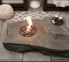 an outdoor fire pit with rocks and candles