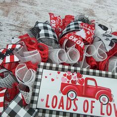 a red truck with lots of love on the front and back is sitting next to a sign that says loads of love