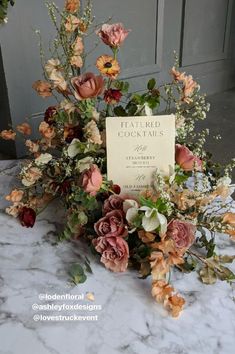 an arrangement of flowers on a table with a sign that says,'featured goods '