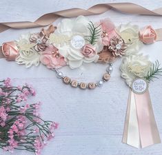 a bouquet of flowers is on display next to a ribbon and some pink flowers are in the foreground