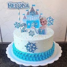 a frozen princess birthday cake with blue frosting and white icing, topped with an ice queen figure