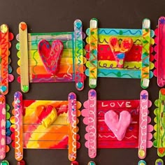 four popsicle crafts are arranged in the shape of frames with hearts and other items