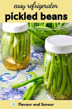 two jars filled with pickled beans sitting on top of a table