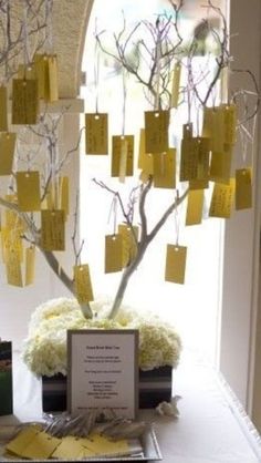 a tree with notes attached to it sitting on top of a table in front of a window