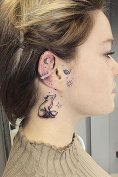 a woman with tattoos on her neck and ear