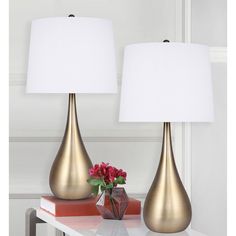 two gold vases with white lamps on a table