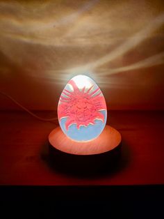 an illuminated egg sitting on top of a wooden table