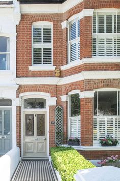 a brick building with white shutters and windows