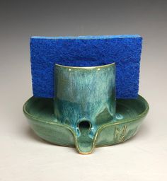 a green cup with a blue sponge on it