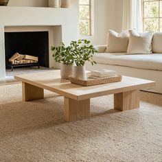 a living room with a couch, coffee table and fire place in the fireplace area