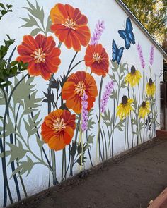 a painted mural on the side of a building with colorful flowers and butterflies in it