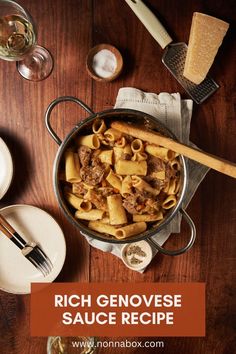 a pot filled with pasta on top of a wooden table next to wine glasses and utensils