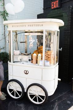 a man standing next to a white cart filled with food